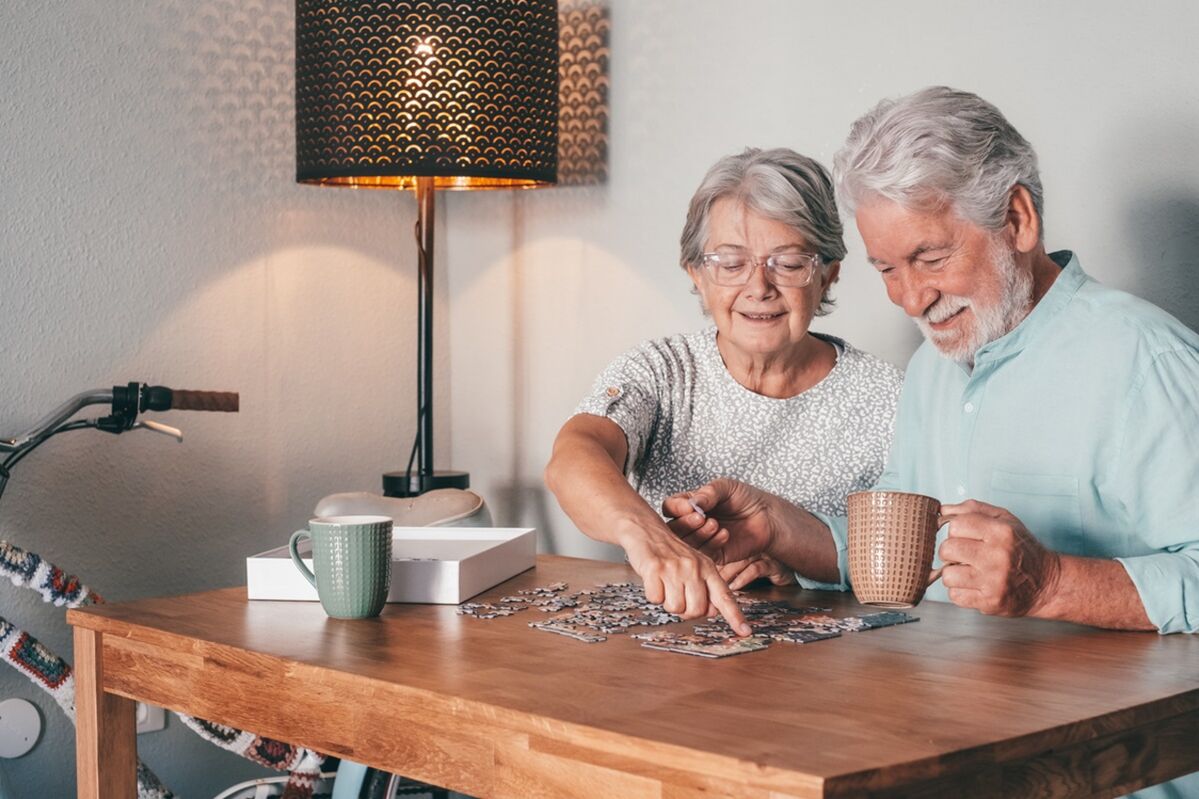 An older couple putting a jigsaw together