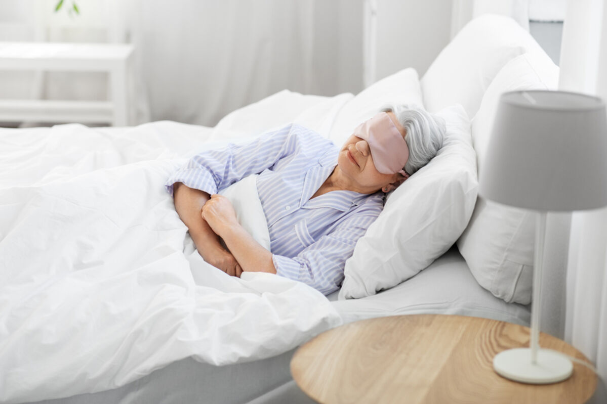 Lady sleeping in her bed with facemask on